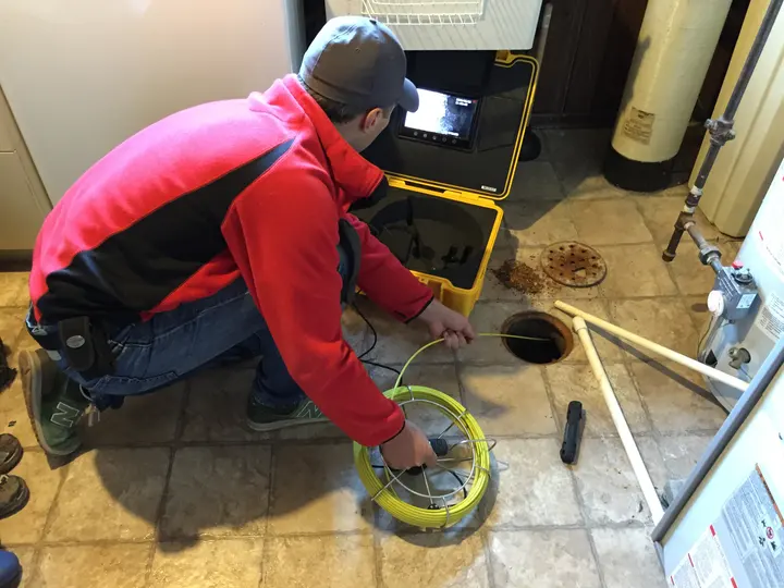 Technicien débouchant une canalisation avec une caméra d'inspection